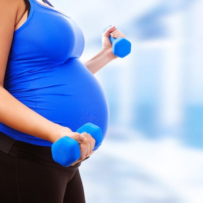 pregnant woman working out with weights