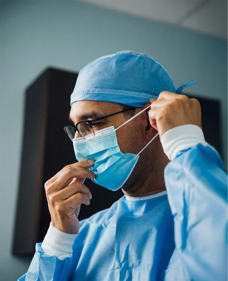 Dr. Haque putting on a blue surgical mask. - Procedures in Charlotte, NC
